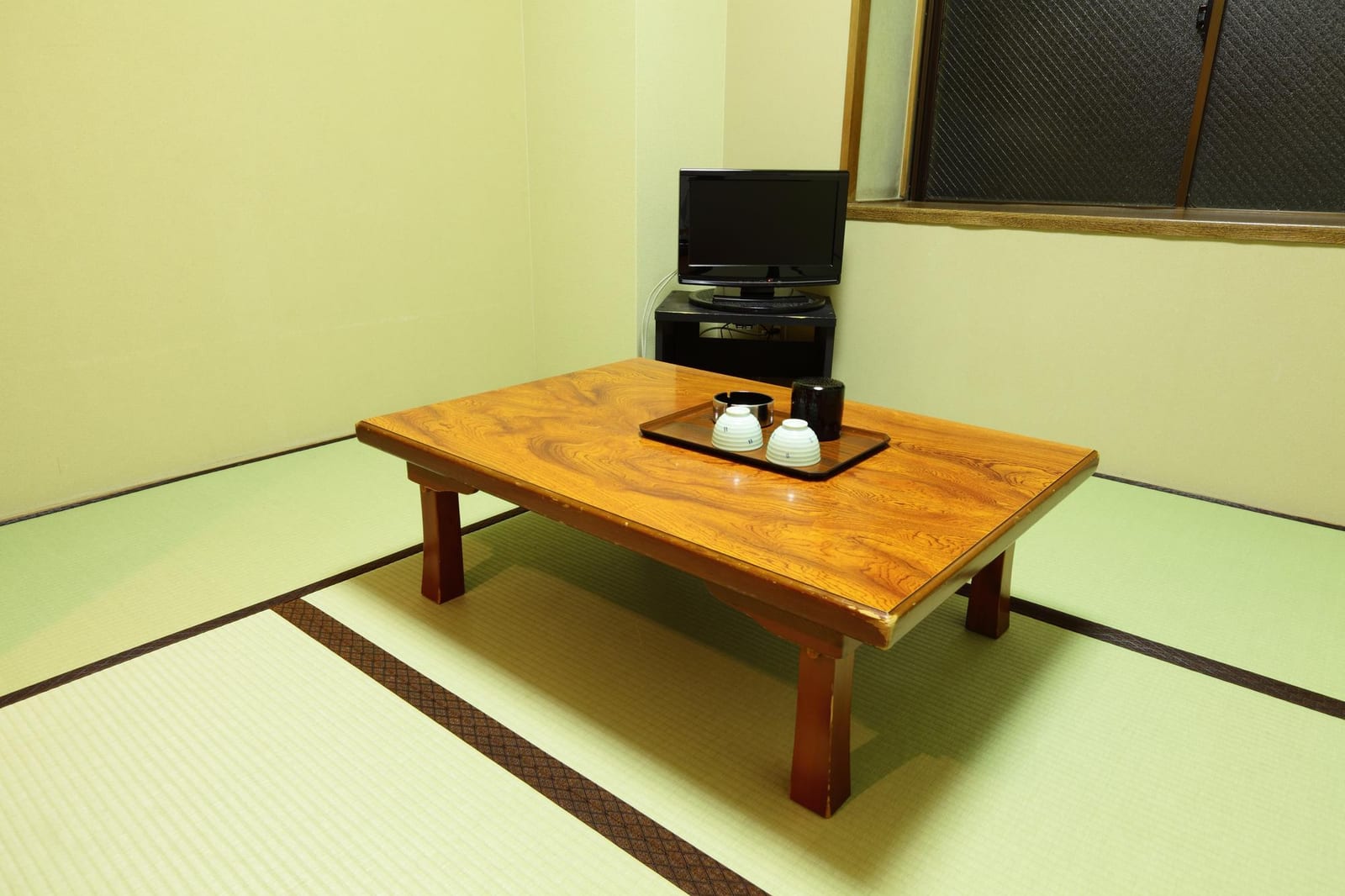 畳の部屋に、湯のみを載せた低い木製のテーブルが置かれている様子