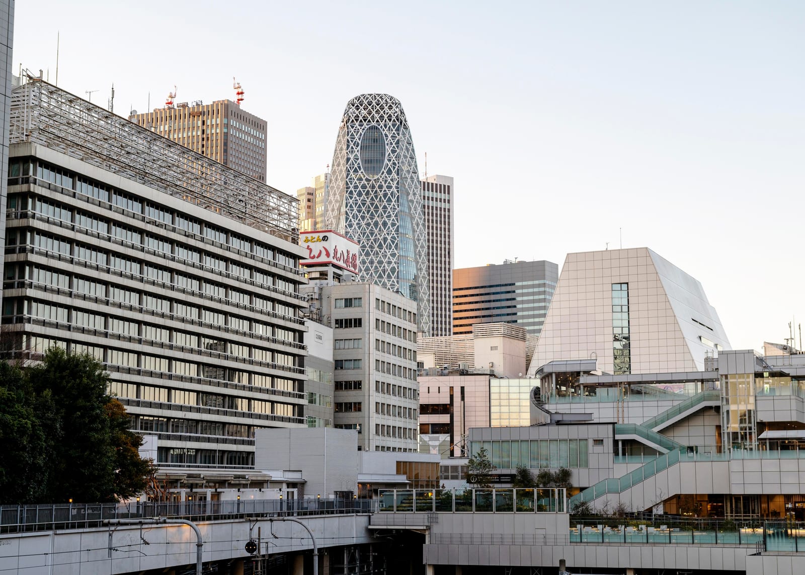 夕暮れの新宿のスカイラインと、オフィスビル群や看板